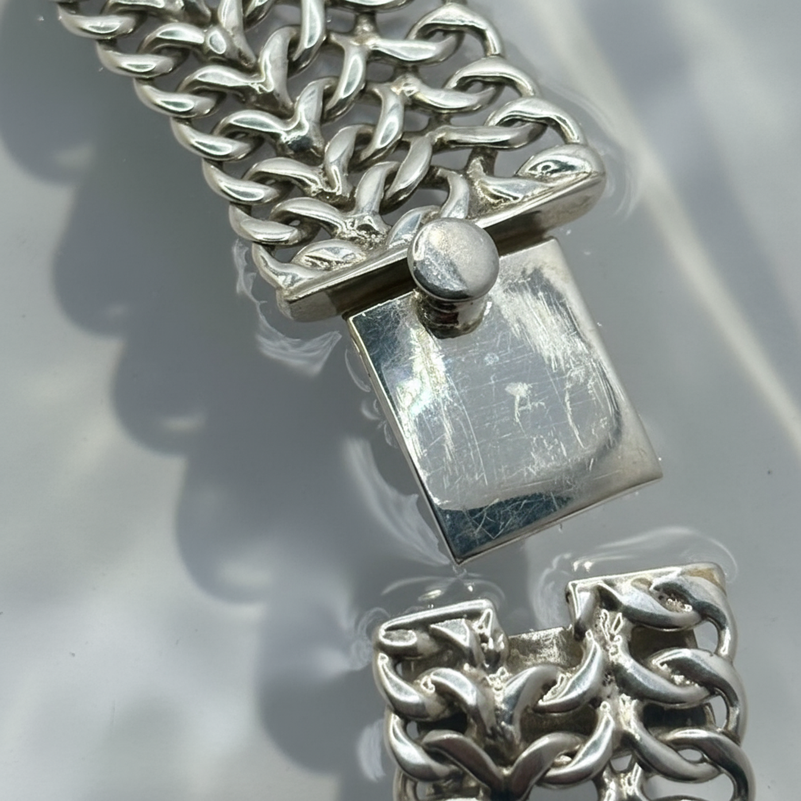 Close-up Emerald Sun showing hand-woven chain links and harmonious neck drape