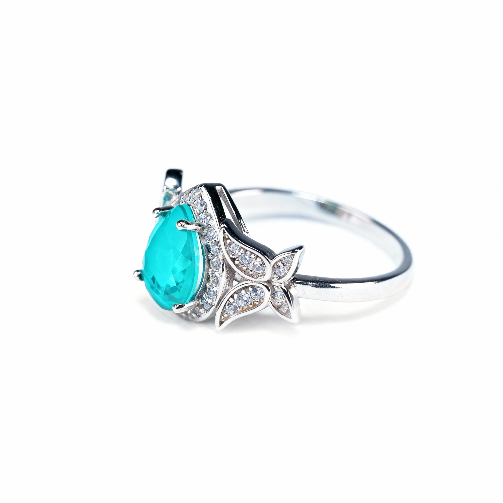 Lotus Tear ring with drop-cut green tourmaline and lotus petal motifs in rhodium silver, front view
