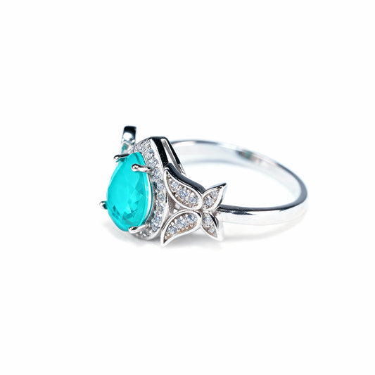 Lotus Tear ring with drop-cut green tourmaline and lotus petal motifs in rhodium silver, front view